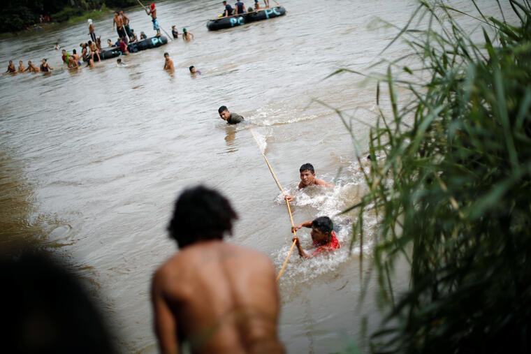 Estos migrantes hondureños cruzan el río Suchiate que divide Guatemala de México. 