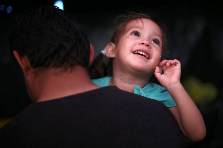 Una niña y su padre caminan junto a la caravana migrante con el objetivo de llegar a suelo estadounidense. 