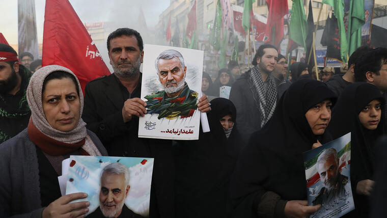 Ciudadanos iraníes en duelo sostienen carteles del general Soleimani en una ceremonia fúnebre para él y sus colegas, asesinados por drones estadounidenses, en la Plaza Enqelab-e-Eslami (de la Revolución Islámica) en Teherán, 6 de enero de 2020.