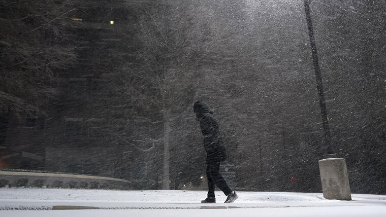 Una mujer camina en medio de una tormenta de nieve en San Antonio, Texas.