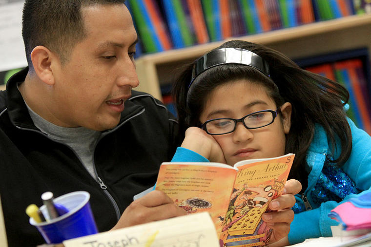 Un padre le lee a su hija en una escuela de Los Ángeles, California