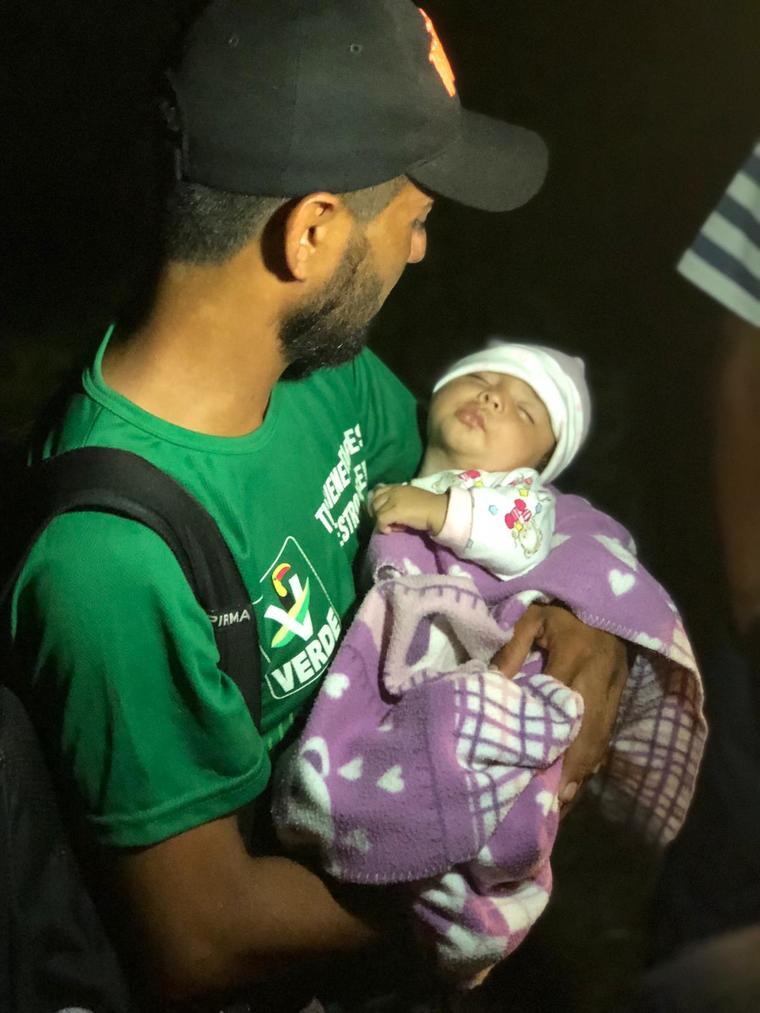 Migrante sujeta a su hija de tres meses en la madrugada de este viernes en Pijijiapan, Chiapas. 