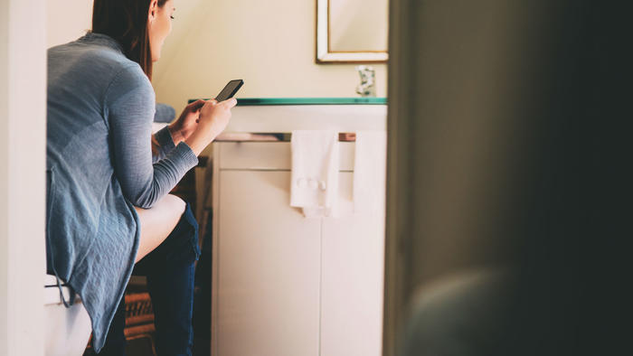 Mujer con smartphone en el WC