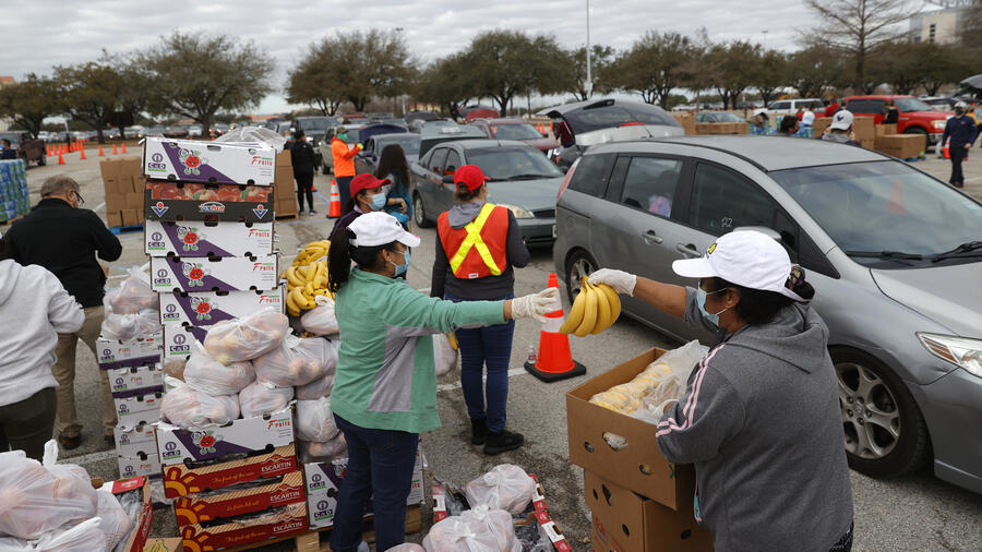 Voluntarios reparten alimentos en un banco de comida en Houston, Texas, este 21 de febrero de 2021.