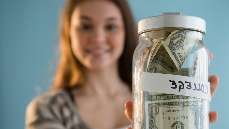 Mujer joven sostiene frasco con dinero
