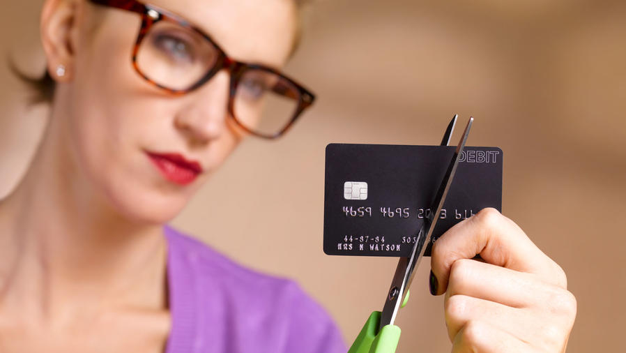 Mujer cortando tarjeta de crédito