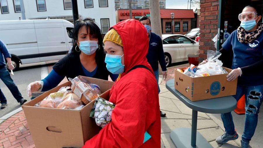 La activista Gladys Vega, a la izquierda, dirige el reparto de alimentos procedentes de donaciones en Chelsea, Massachussetts, ciudad con alta presencia de latinos. 