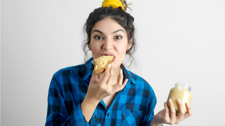 Mujer comiendo un pan con mantequilla de maní