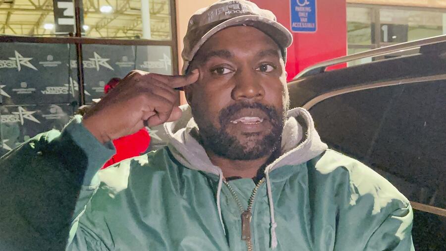 Kanye West apuntándose la sien con la mano.