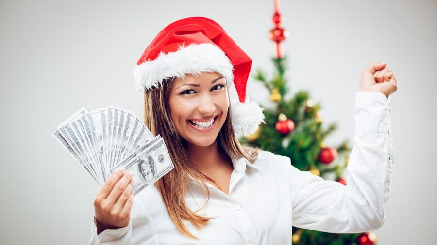 Mujer con dinero en la mano usando un gorro de Navidad