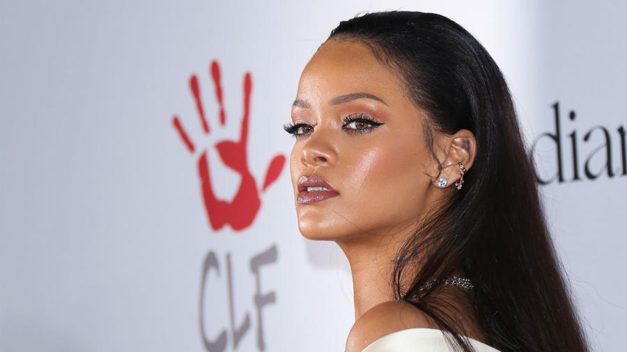 Rihanna de pie frente al logo de The Clara Lionel Foundation