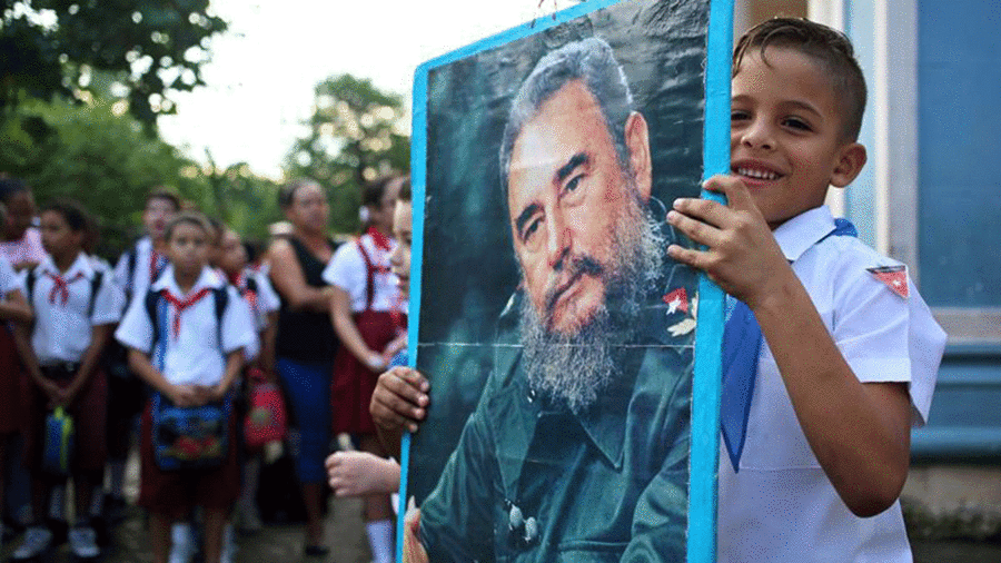 Niño porta un retrato de Fidel Castro en el primer aniversario de su muerte
