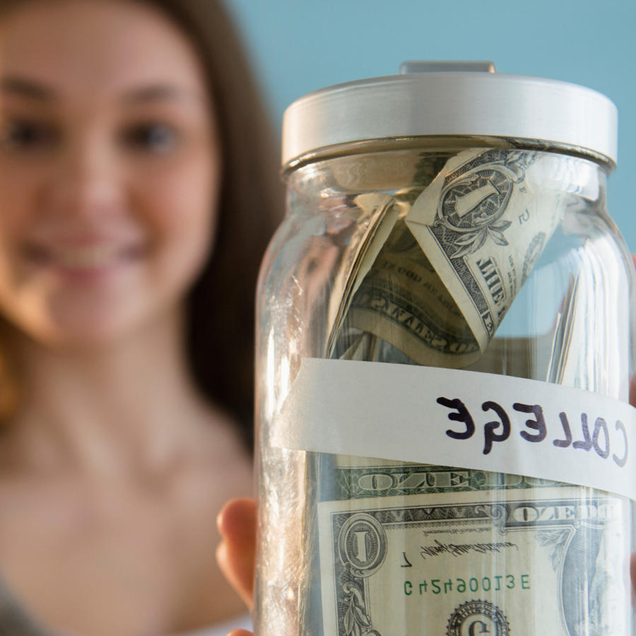 Mujer joven sostiene frasco con dinero