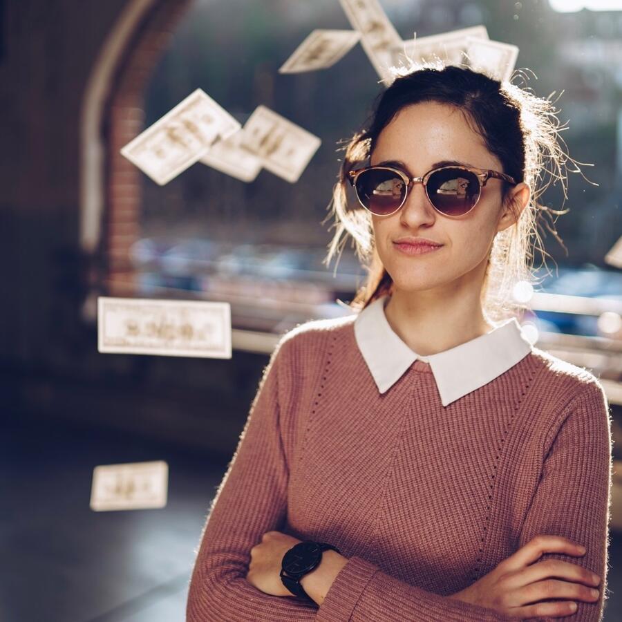 Mujer exitosa con dinero detrás de ella