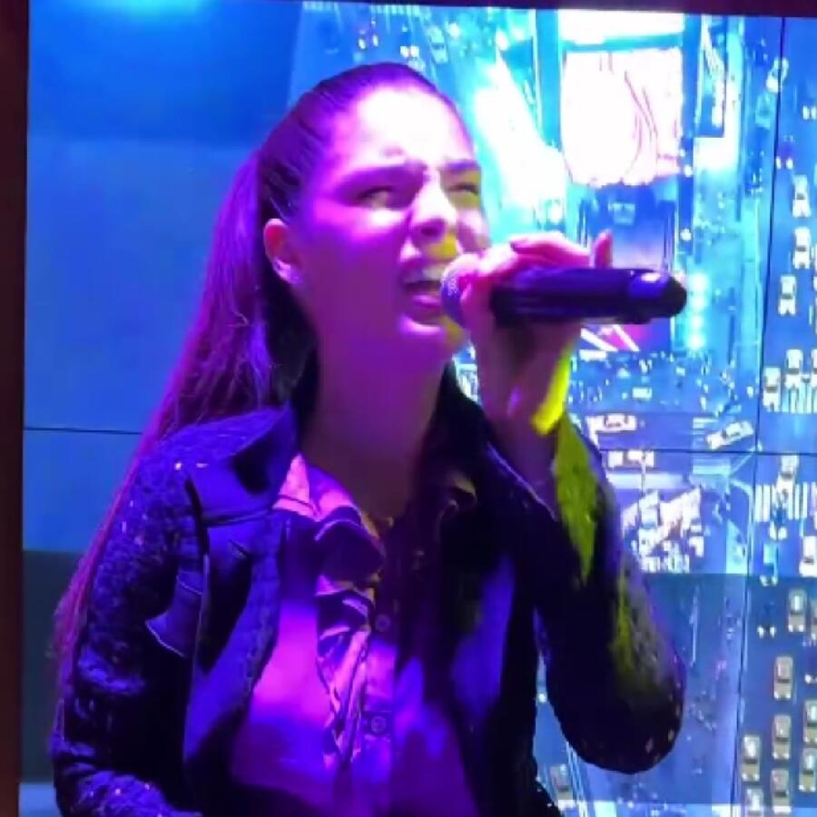 Nadia Ferreira cantando en un karaoke