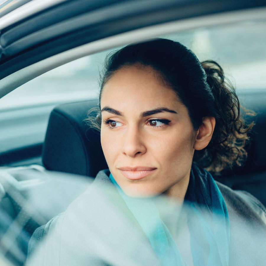 Mujer sentada en el asiento trasero de un coche