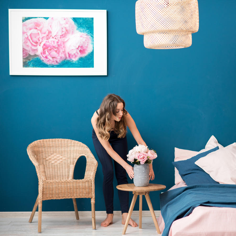 Mujer decorando su habitación llena de colores vibrantes.