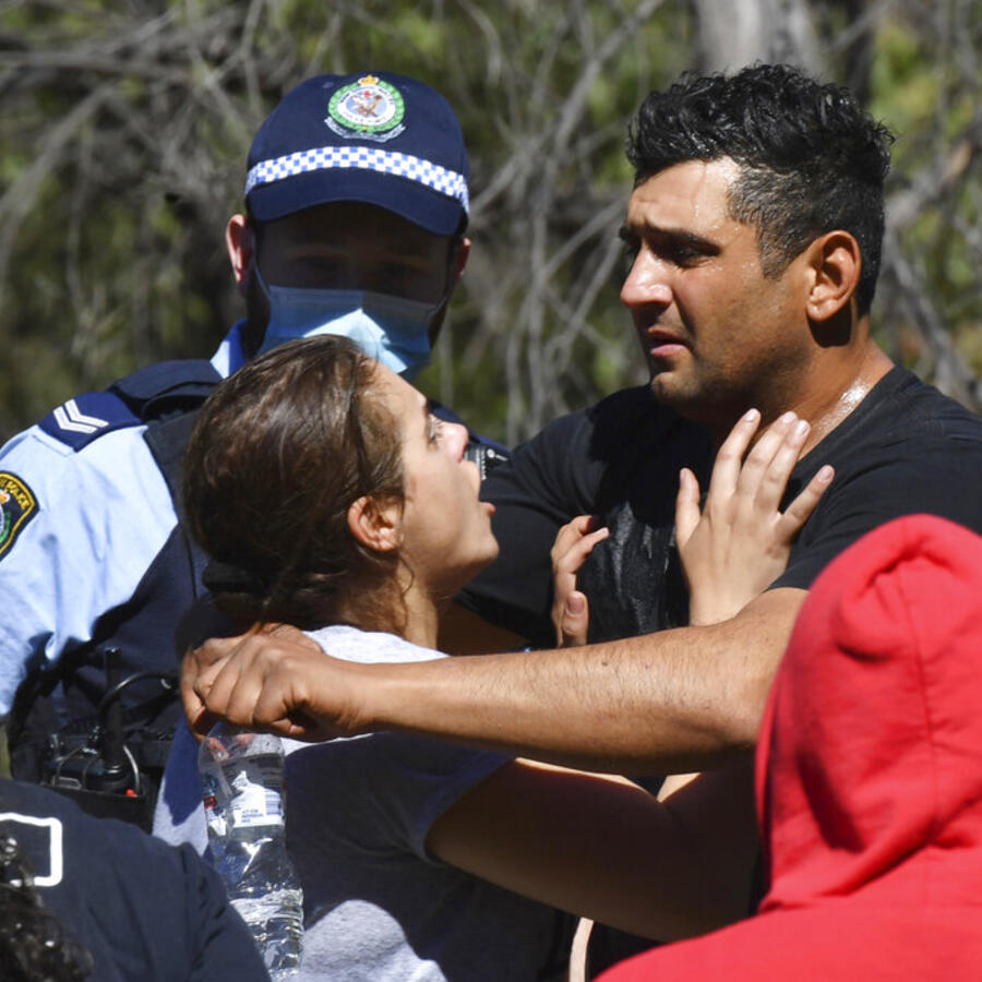 Anthony Elfalak, a la derecha, y su esposa Kelly, se abrazan al conocer la noticia de que su hijo AJ fue localizado con vida en una propiedad de la familia en Putty, al noroeste de Australia, el 6 de septiembre de 2021.