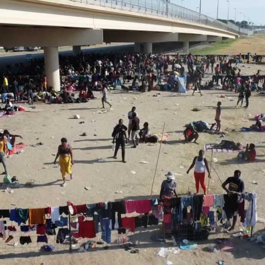 Migrantes esperan bajo el Puente Internacional Del Río a ser procesados por las autoridades fronterizas