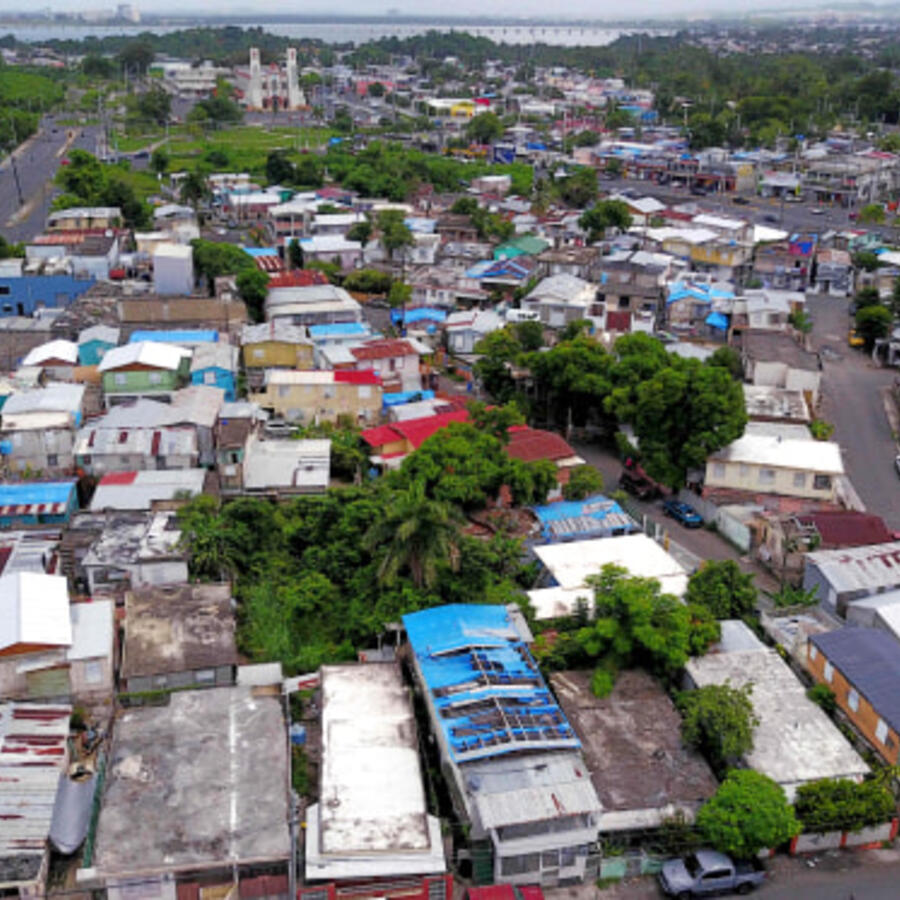 Lonas azules repartidas por FEMA cubren varios techos de viviendas dañadas en Puerto Rico dos años después del huracán María.