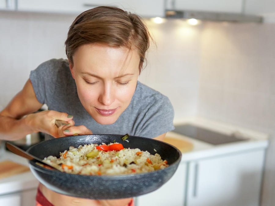 Mujer saboreando un platillo con arroz.