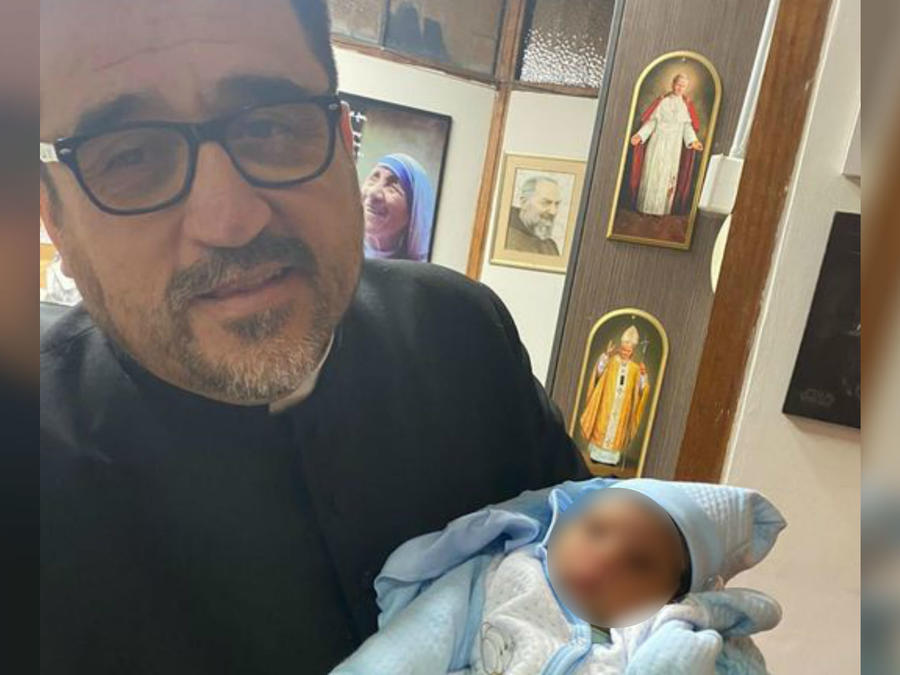 Padre Omar junto a bebe