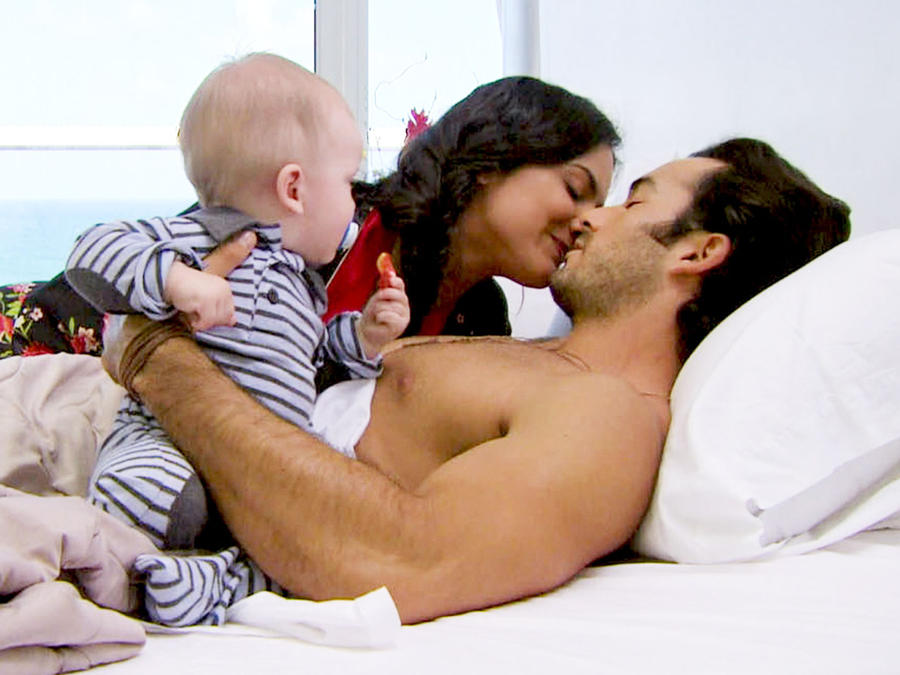 Ana Lorena Sánchez y Aarón Díaz besándose en la cama junto a su bebé en Tierra de Reyes