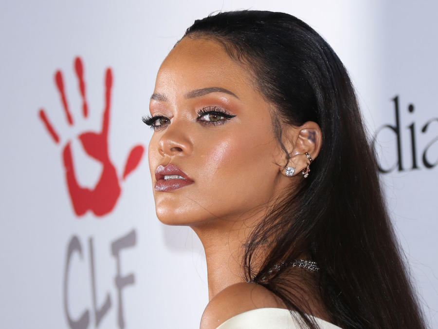 Rihanna de pie frente al logo de The Clara Lionel Foundation