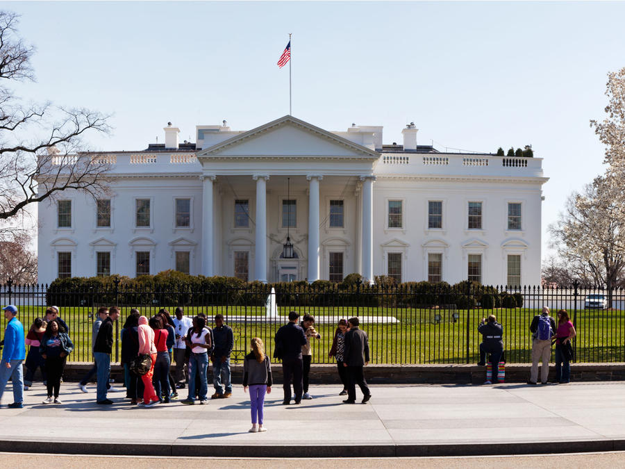 Niña de espaldas parada afuera de la Casa Blanca