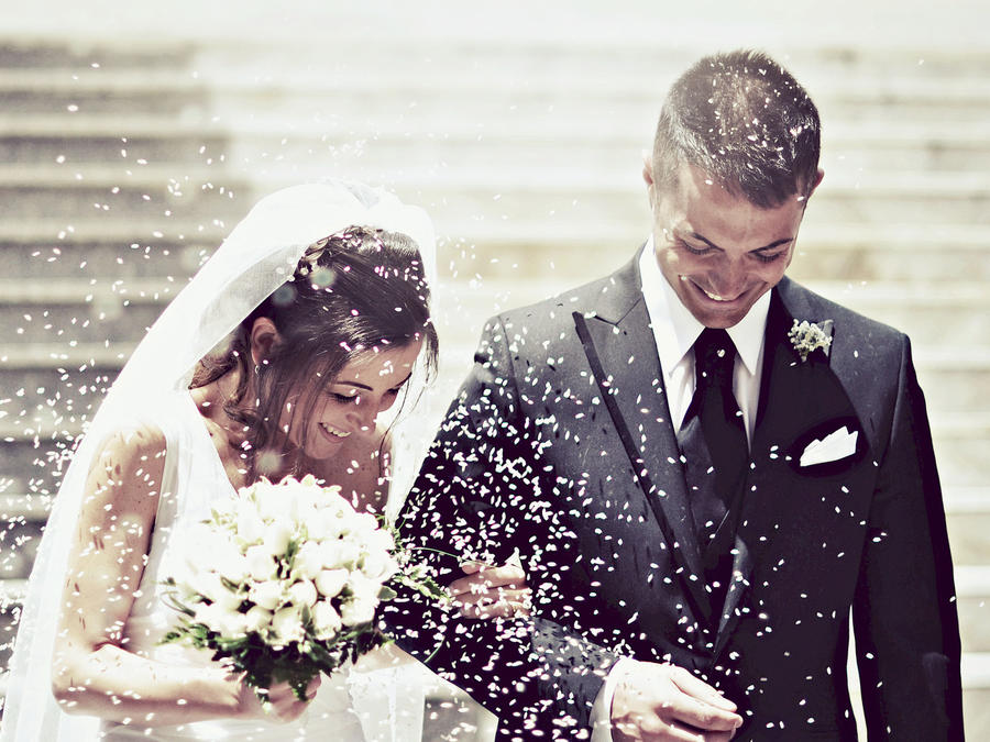 Pareja de recién casados bajo una lluvia de arroz