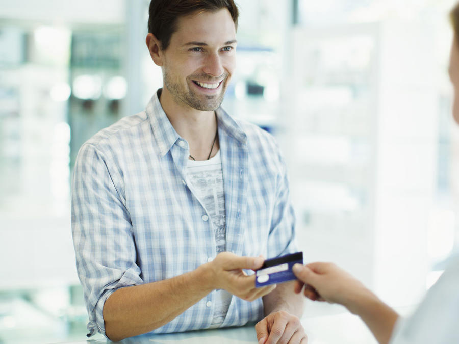 Hombre joven haciendo un pago con su tarjeta de crédito
