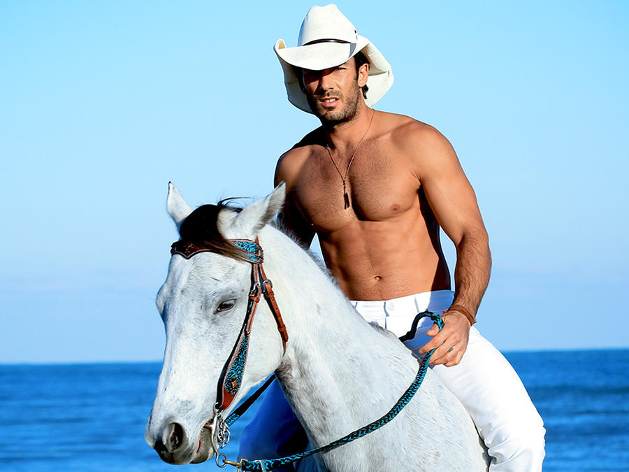Aarón Díaz montando a caballo sin camisa en la playa en Tierra de Reyes
