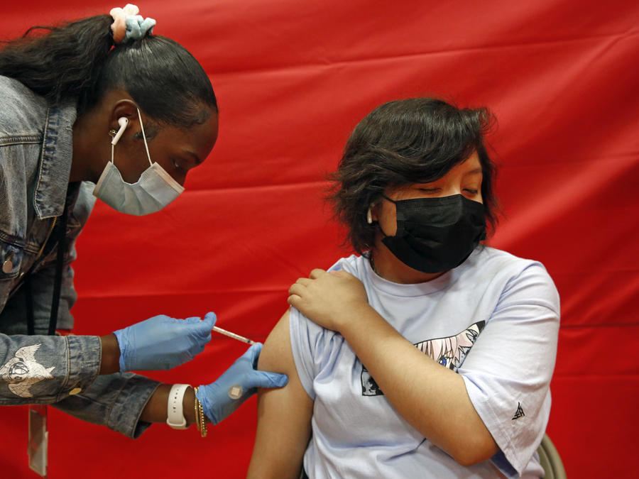 Alex Olvera, de 15 años, recibe la vacuna de Pfizer contra el COVID-19 de la mano de la enfermera Rickeyva Foster, en una escuela de los Ángeles California, el 17 de mayo de 2021.