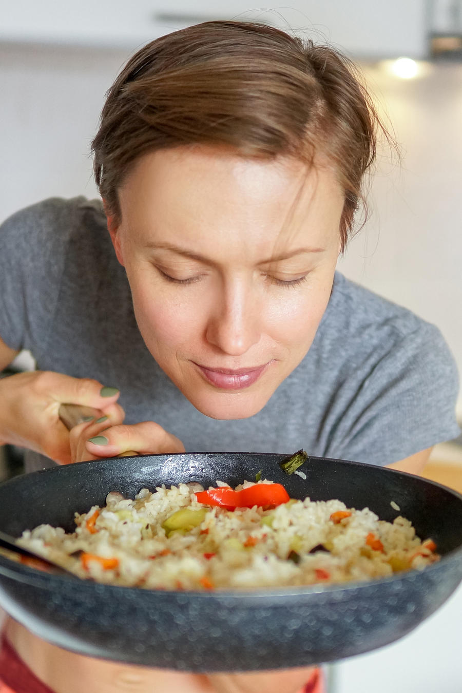 Mujer saboreando un platillo con arroz.