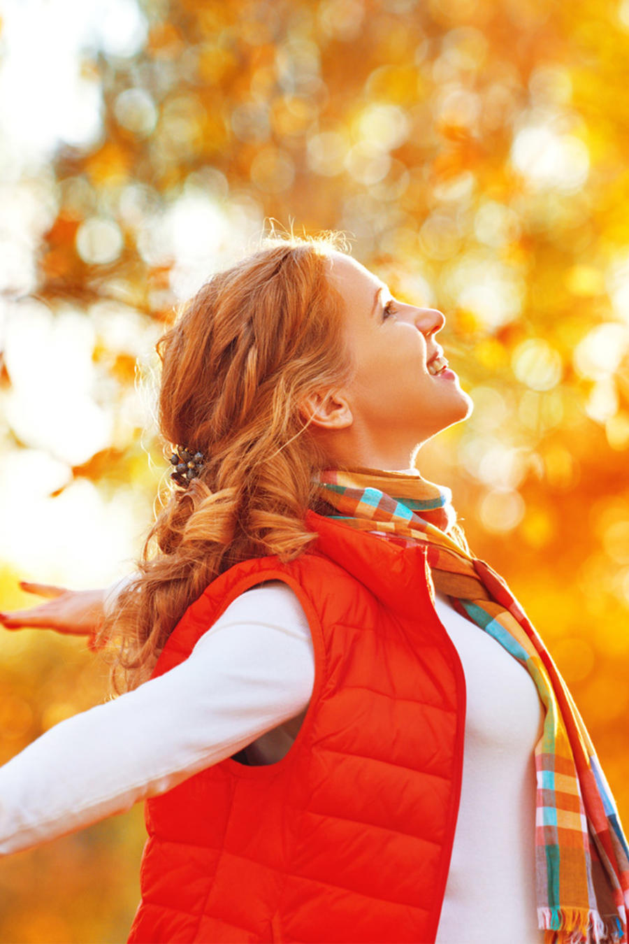 Mujer feliz respira entre árboles de otoño