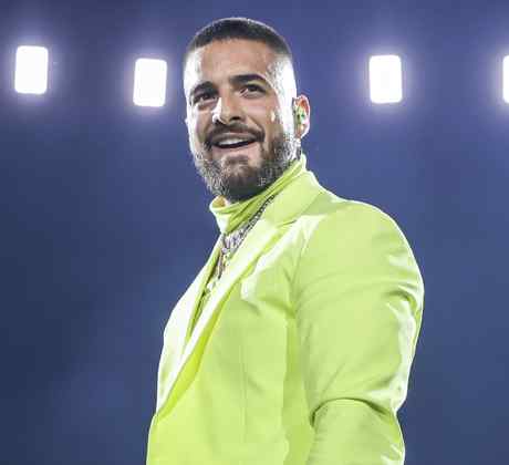 Maluma wearing a neon outfit during live show.